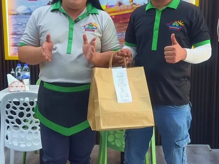 Two of the team with a packed takeaway order at Pinoy Tambayan